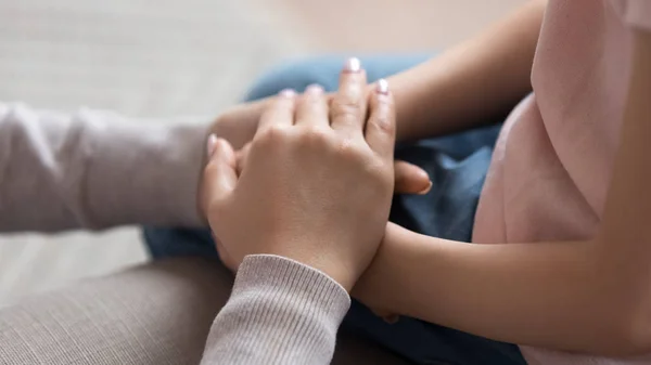 Mamá dando confianza de apoyo a la pequeña hija cogida de la mano, primer plano — Foto de Stock