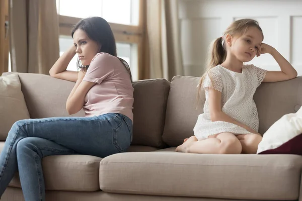 Упрямая мать и девочка, сидящие отвернулись от дивана — стоковое фото