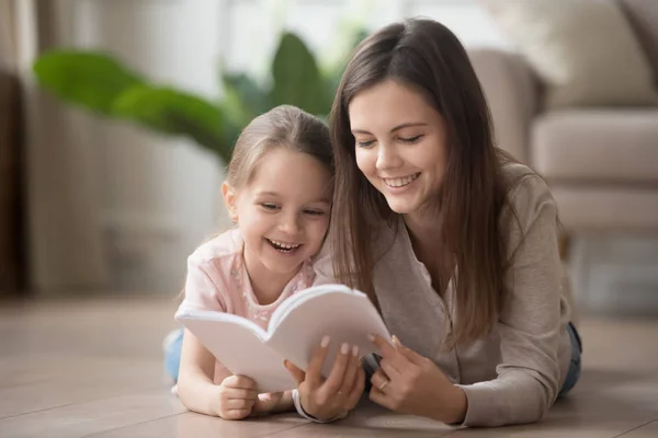 Feliz familia mamá niñera y niño hija lectura libro —  Fotos de Stock