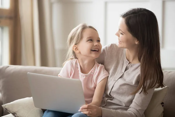 Boldog anya és a gyerek lánya nevető birtoklás móka-val laptop — Stock Fotó
