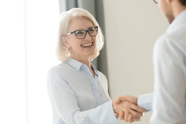 Gelukkig volwassen zakenvrouw handshaking partner client, vertrouwen en dankbaarheid handdruk — Stockfoto