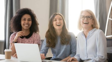 Toplantıda nişanlı gülüyor çeşitli mutlu genç ve yaşlı busineswomen