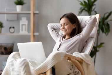 Online video izlerken bilgisayar üzerinde sallanan sandalye üzerinde oturan kadın