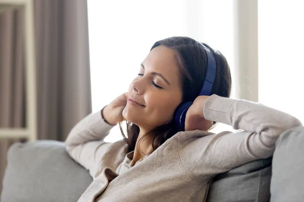 Lachende jonge vrouw dragen hoofdtelefoon geniet van favoriete muziek — Stockfoto