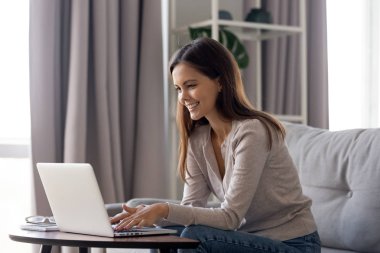 Kadın internet eğleniyor kanepede oturan gülümseyen