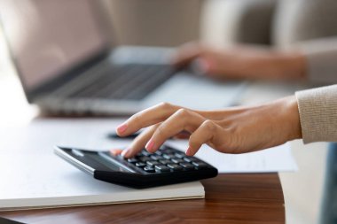 Hesap makinesi ve bilgisayar kullanan kırpılmış portre resim beyaz kadın