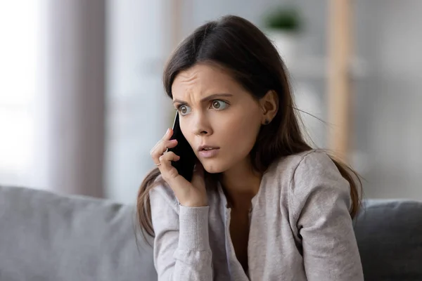 Mujer joven conmocionada o asustada hablando por teléfono móvil — Foto de Stock