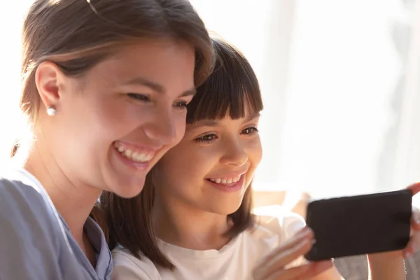 Close up divertente madre e figlia guardando lo schermo dello smartphone — Foto Stock