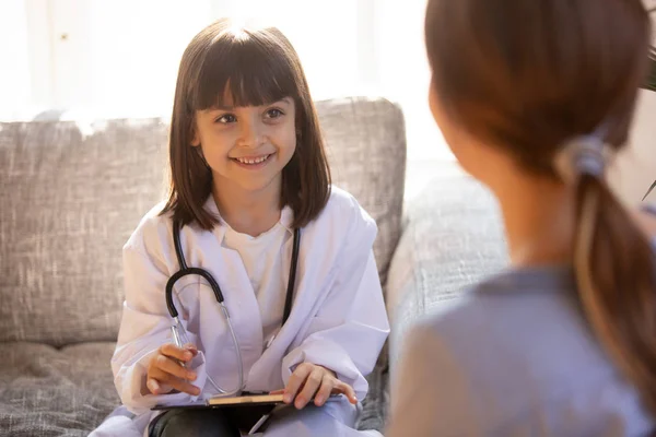 Küçük kız doktor anne ile oynayan doktor beyaz ceket giyiyor — Stok fotoğraf