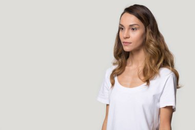 Ciddi çekici kadın daire poz gri arka plan üzerinde bir kenara