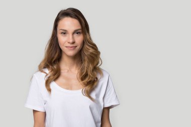 Kadın kamera görünümlü gri arka plan üzerinde stüdyoda poz