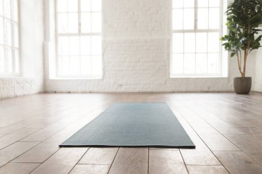 Yoga stüdyosunda boş oda, katta yuvarlanmış yoga mat