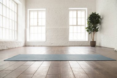 Yoga stüdyosunda ahşap katta yuvarlanmış yoga mat