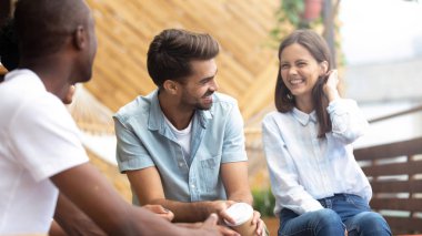 Çok kültürlü mutlu insanlar terasta Reunion toplantısında konuşurken gülüyor