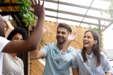 Mutlu çok kültürlü genç insanlar arkadaşlar grup gülmek yüksek beş vermek