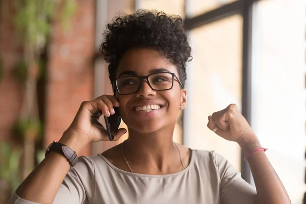 Mujer africana emocionada hablando por teléfono feliz por las buenas noticias —  Fotos de Stock