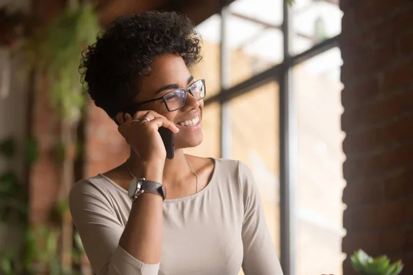 Šťastná africká americká mladá žena telefonovala v kanceláři — Stock fotografie