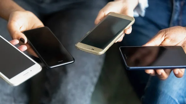 Male and female hands holding phones, close up view — Stock Photo, Image