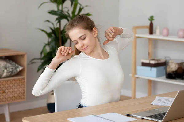 Jovem mulher satisfeita alongamento, fazendo exercício no local de trabalho — Fotografia de Stock