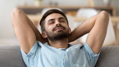 Sakin huzurlu adam kanepede geri eğilerek kapalı gözleri ile rahatlatıcı