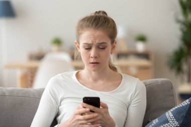 Üzgün kadın telefon kullanarak, kötü haber okuma, ekrana bakıyor