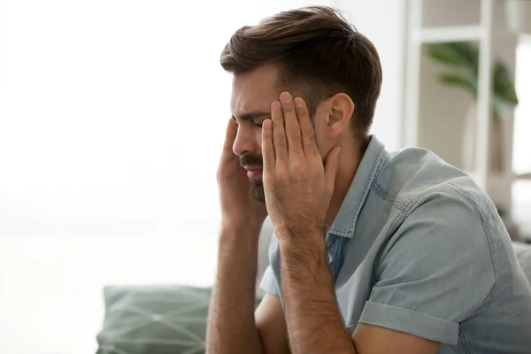 Hombre cansado molesto que sufre de dolor de cabeza, tocando las sienes de cerca —  Fotos de Stock