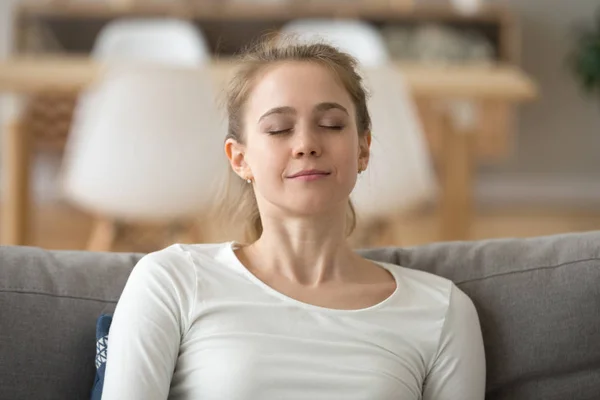 Közelről nyugodt békés nő pihentető csukott szemmel a kanapén — Stock Fotó