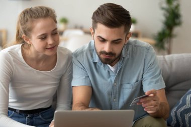 Genç çift alışveriş online, kredi kartı ile satın almak için ödeme