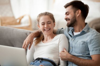 Evde eğlenceli birlikte, dizüstü bilgisayar kullanarak aşk gülüyor çift