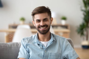 Evde kanepede oturan mutlu gülümseyen adam kafa shot portre