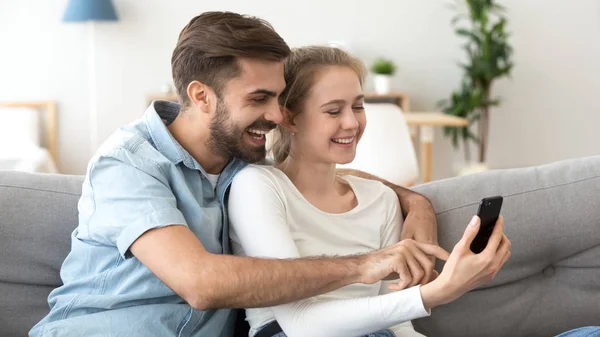 Heureux homme et femme s'amuser avec smartphone ensemble — Photo
