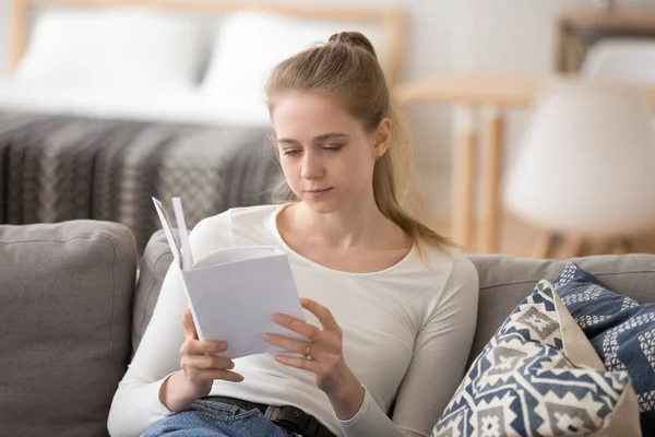 Ciddi odaklı kız kitap okuma, evde rahat kanepede oturan — Stok fotoğraf