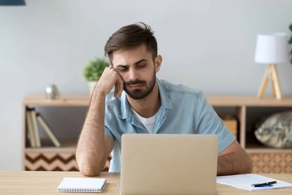 Estudante cansado ou empregado trabalhando com laptop, fazendo um trabalho chato — Fotografia de Stock