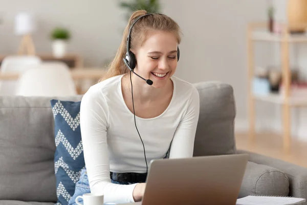 Glimlachende vrouw dragen headset, met behulp van laptop, kijken op het scherm — Stockfoto