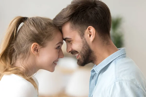Close up smiling couple in love touching forehead, enjoying tender moment — Stock Photo, Image