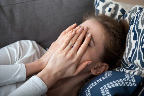 Közelről ideges frusztrált nő, amely arcát a kezét, feküdt a kanapén — Stock Fotó