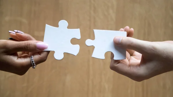 Diverse man and woman hands holding joining pieces connecting puzzle — Stock Photo, Image