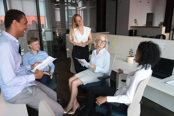 Old leader talking to team presenting work plan at meeting