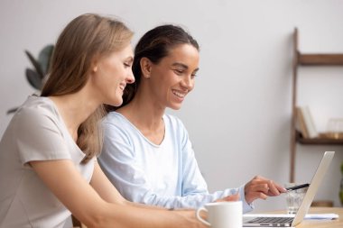 İki mutlu iş kadını birlikte çalışma ofiste dizüstü bilgisayar işbirliği
