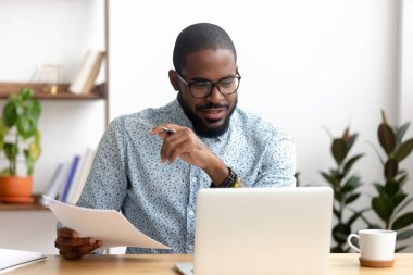 Ofis dizüstü belgeler ile çalışan odaklı Afrikalı Amerikan işadamı