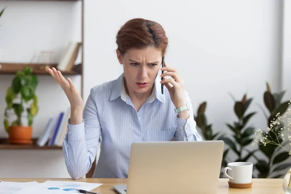 Loca mujer de negocios enojada hablando por teléfono mirando el portátil — Foto de Stock