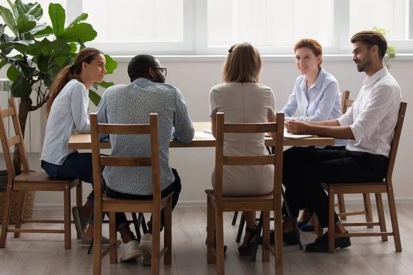 Diverso equipo de negocios de oficina hablando sentado en la mesa en la sala de juntas —  Fotos de Stock