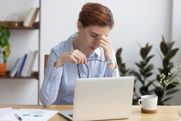 Mujer de negocios estresada con exceso de trabajo sosteniendo gafas siente tensión ocular —  Fotos de Stock