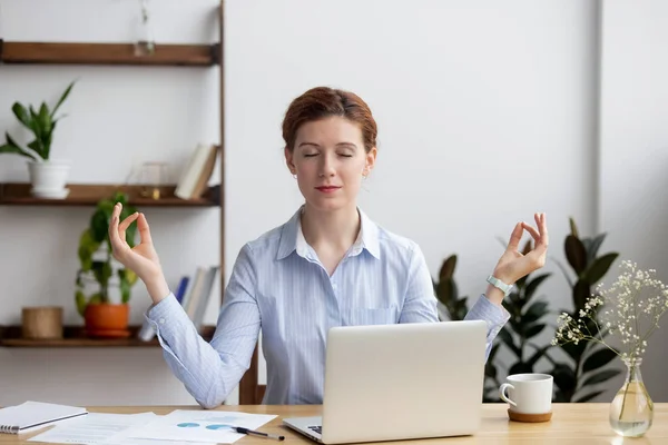 Спокойная здоровая деловая женщина медитирует расслабляясь на рабочем столе — стоковое фото