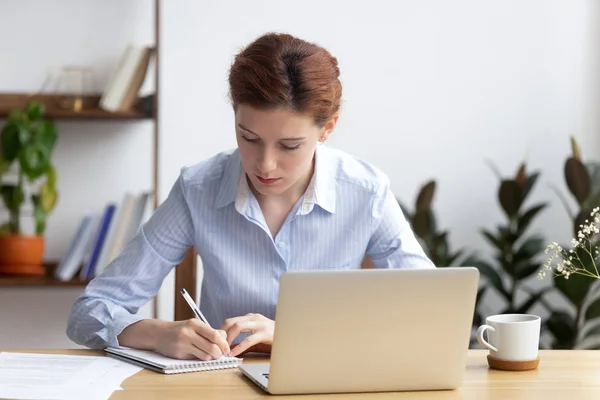 Focalizzato millenaria impresa donna ufficio lavoratore prendere appunti pianificazione lavoro — Foto Stock