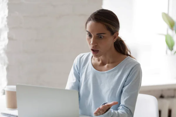 Mujer conmocionada y estresada mirando la pantalla del ordenador portátil — Foto de Stock