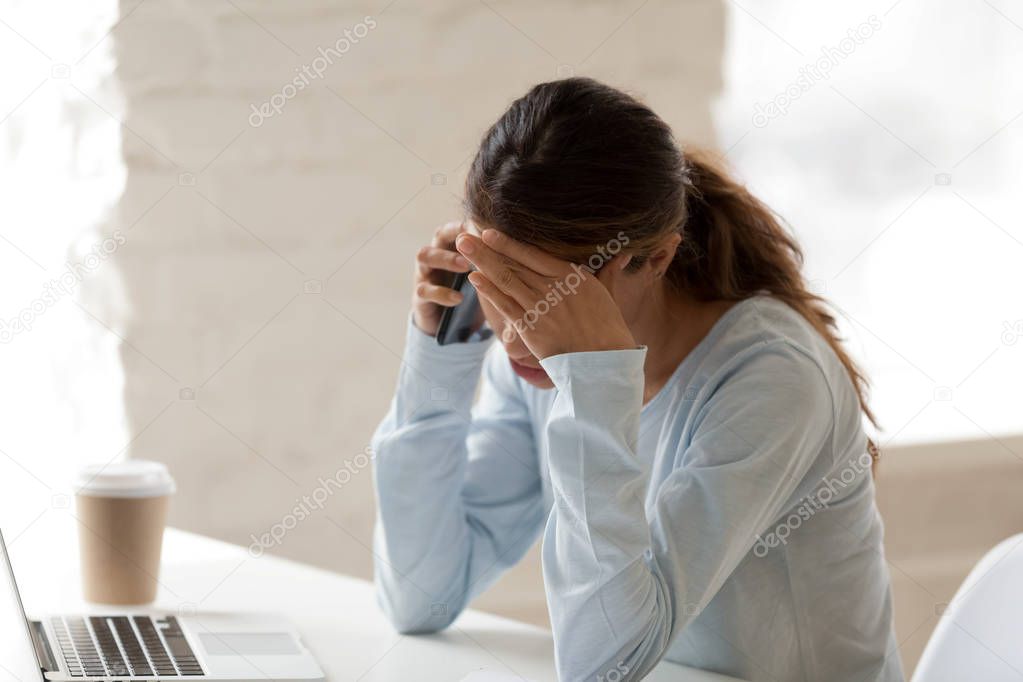 Stressed woman at work putting hand on her forehead
