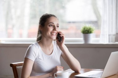 Mutlu gülümseyen kadın evde sabah telefonla konuşurken