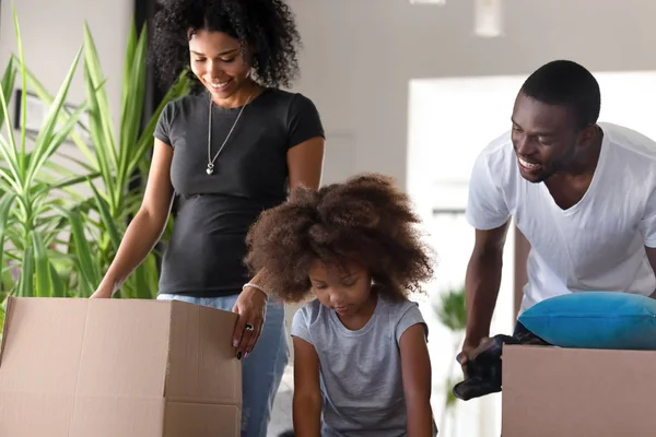 Gelukkig African American ouders met dochter uitpakken dozen in nieuw huis — Stockfoto