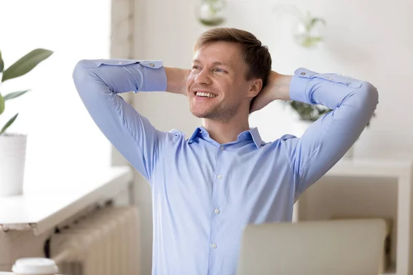 Homme rêvant avec un sourire heureux avec les mains serrées derrière la tête — Photo